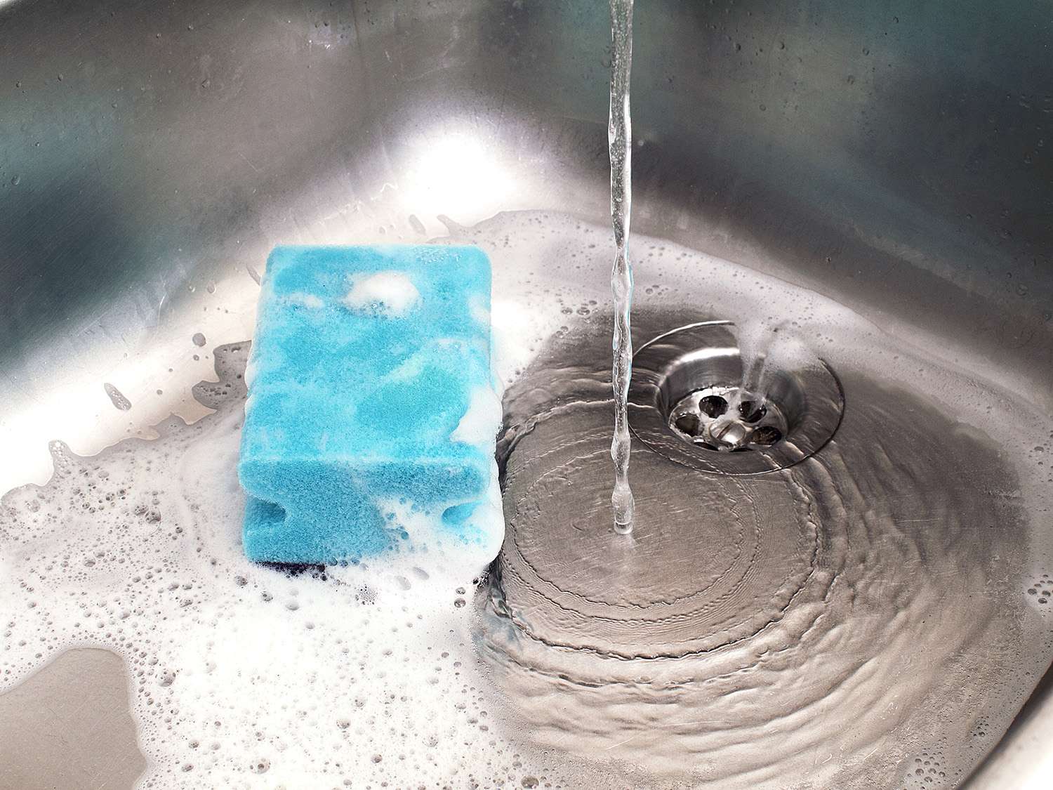 Soapy water draining down a sink